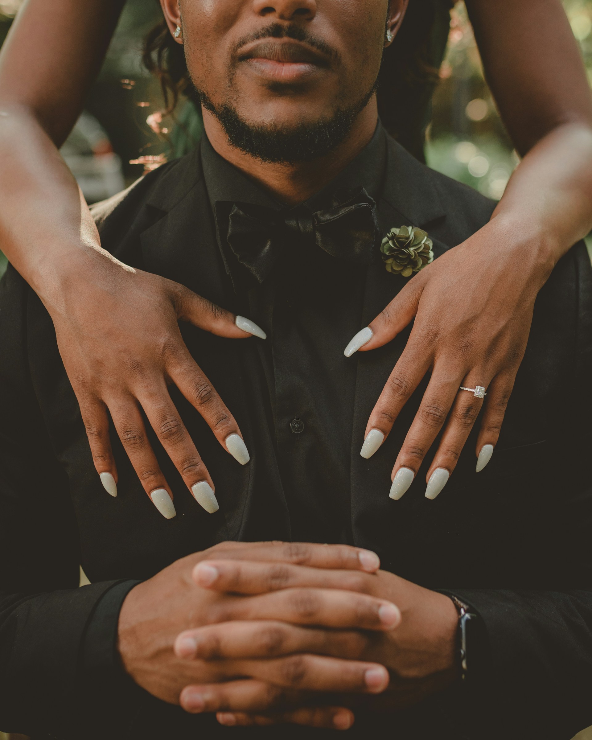 man sitting in chair with woman standing behind him Man sitting in chair with woman standing behind him